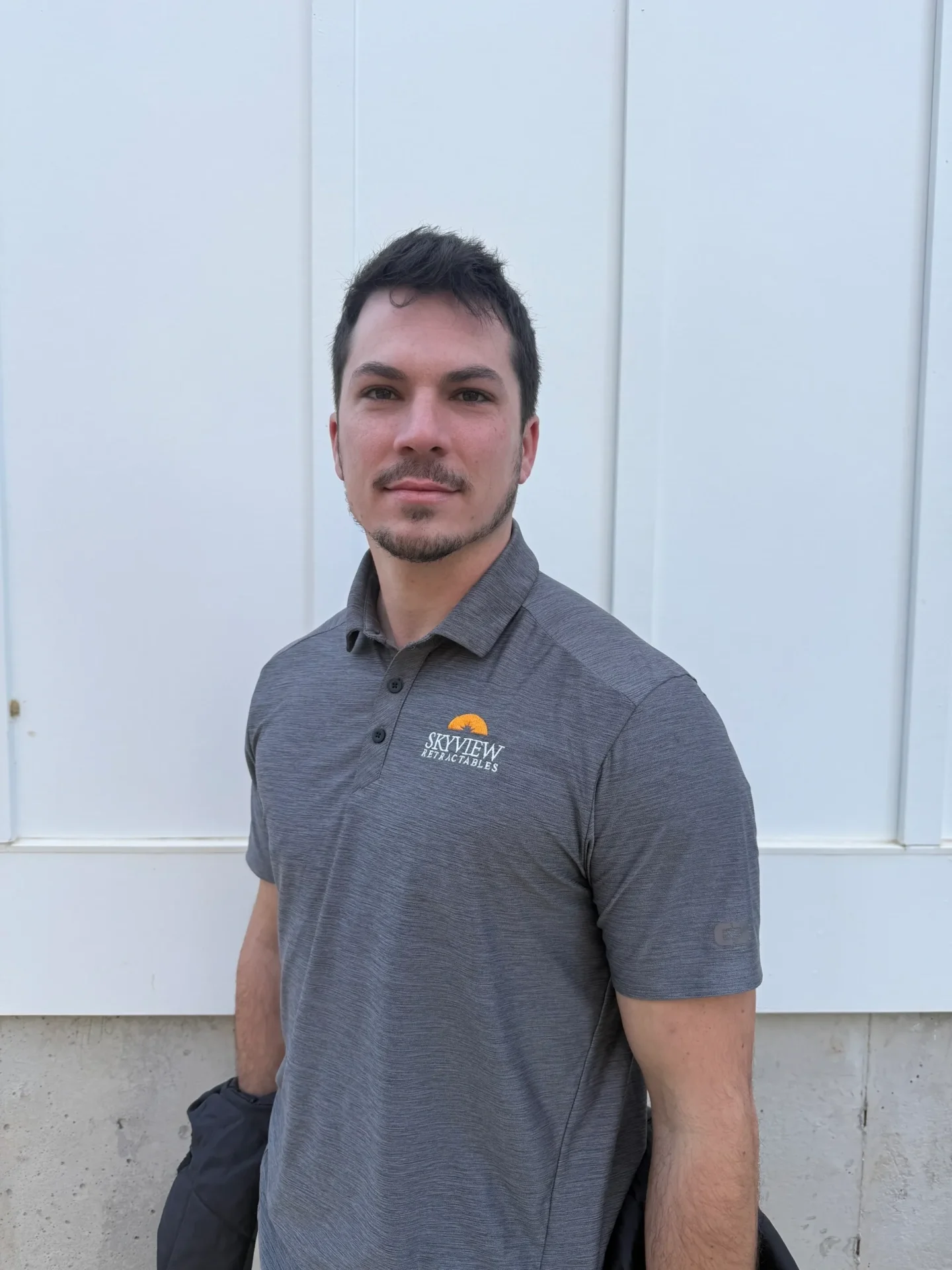 A man standing wearing a gray tshirt