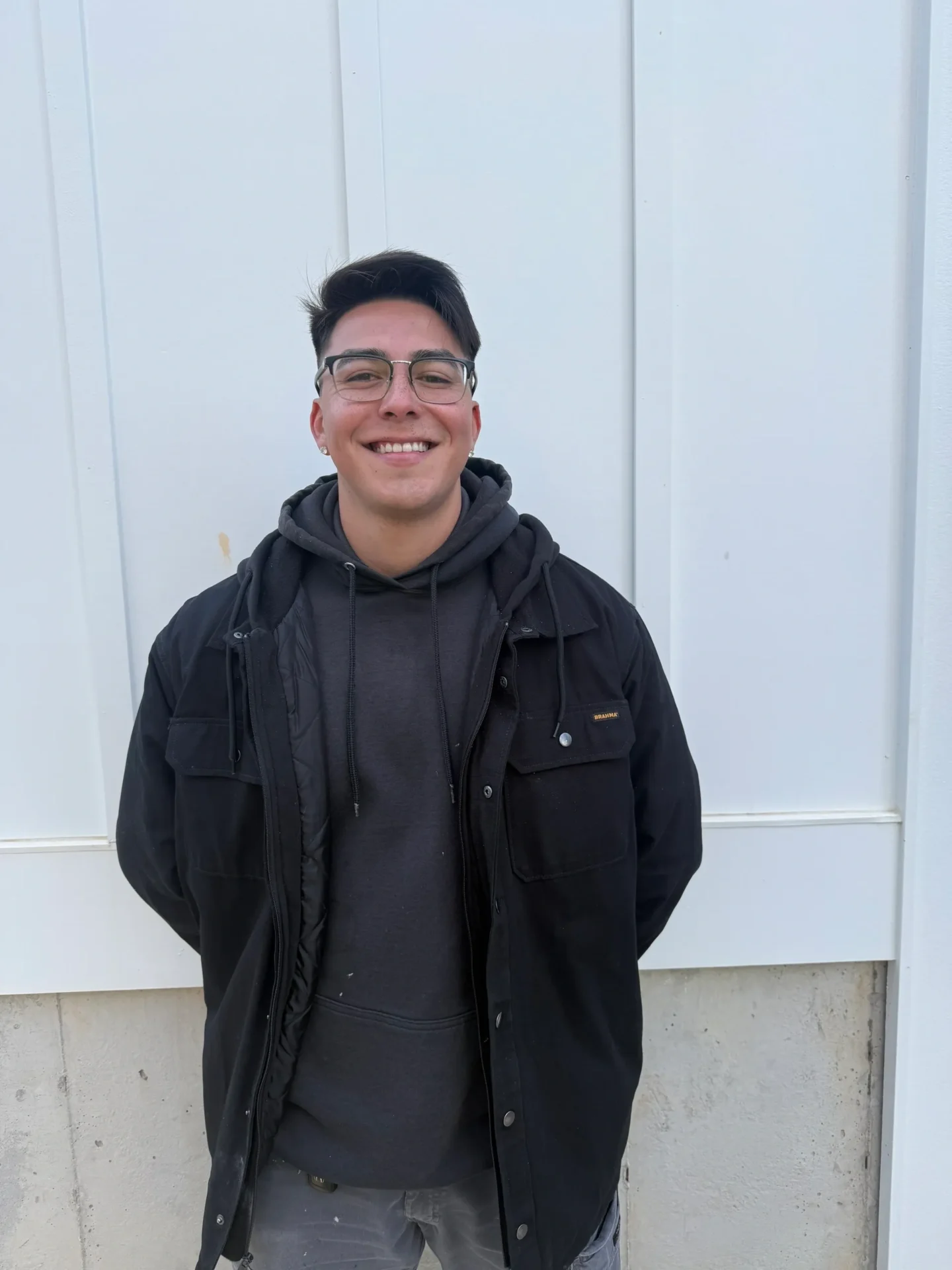 A man wearing black jacked and standing